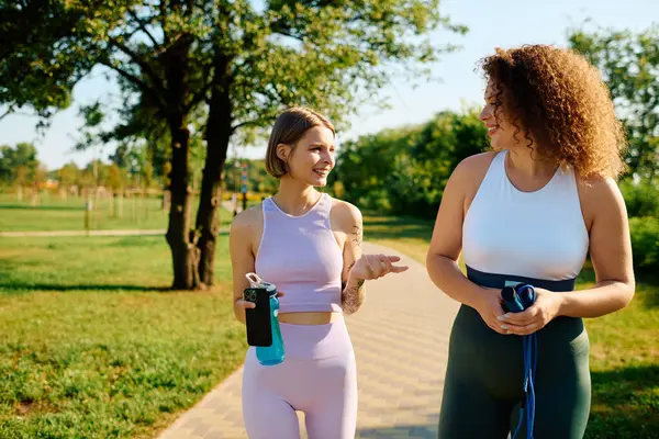 stock image Lesbian couple shares joyful moments while walking in a vibrant park.