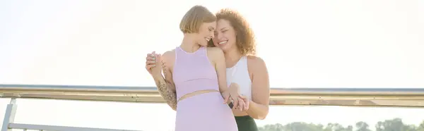 stock image Two women embrace in a park, radiating happiness under the warm sun.