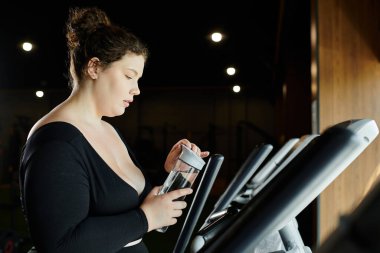 A plus-size woman confidently workouts in her active wear, focused on her fitness journey at the gym. clipart