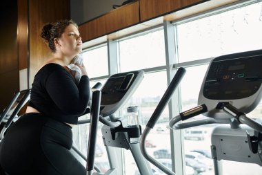 Genç bir kadın spor yapıyor, aktif giysisindeki pozitifliği kucaklıyor..