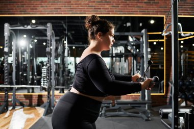 Büyük beden bir kadın spor yapar, spor yaparken güçlü ve pozitiftir..