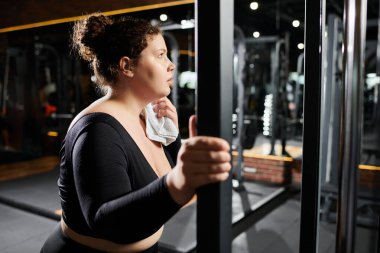 Büyük beden bir kadın spor salonundaki vücut pozitifliğini göstermek için egzersiz rutinine odaklanır..