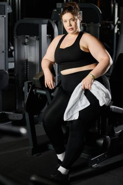 Genç bir kadın spor salonunda vücut pozitifliği ve gücü somutlaştıran bir egzersize katılır..
