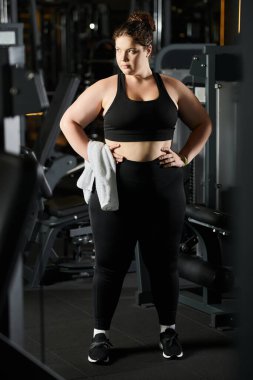 Spor salonunda vücut pozitifliğini destekleyen, aktif kıyafet egzersizi yapan kendine güvenen genç bir kadın..