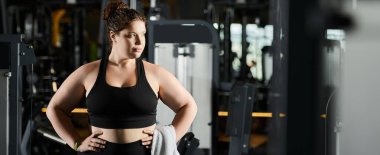 Aktif giysili genç bir kadın spor salonunda egzersiz yaparken kendini güçlendiriyor..
