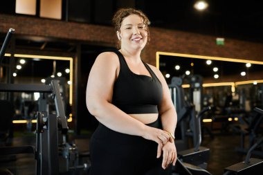 Büyük beden bir kadın şık ve aktif bir spor salonunda spor yaparken spor yaparken spor yapmayı benimsiyor..