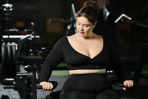 Stock image A young plus-size woman works out in active wear, radiating confidence and strength in the gym.