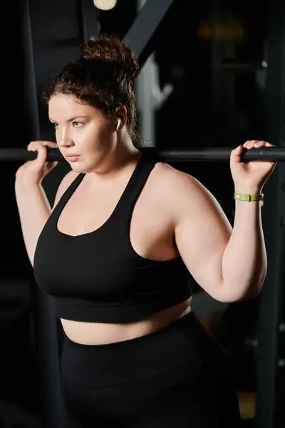 Stock image Focusing intently, a plus-size woman lifts weights, showcasing confidence and empowerment during her workout.