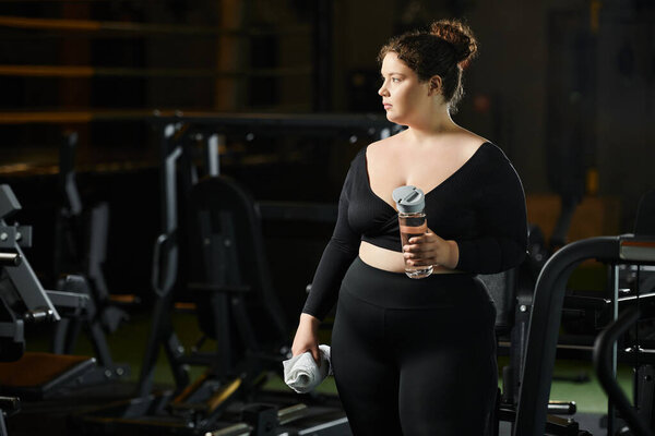 Молодая женщина обнимает тело позитивности во время занятий в стильной спортивной форме в тренажерном зале.