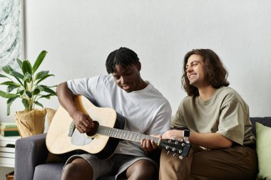 İki ortak evde keyifli bir öğleden sonra geçiriyorlar gitar çalıp gülüyorlar..