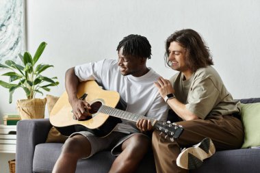 İki ortak aynı mutlu anı paylaşıyor, gitar çalıp birbirlerinin evinde eğleniyorlar..