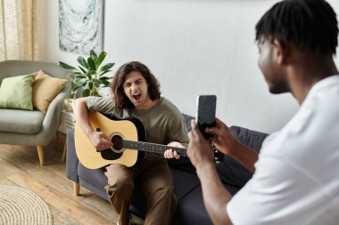 Sevgi dolu bir çift, biri gitar çalarken diğeri anı yakalar..