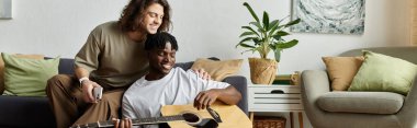 İki partner evde müzik çalarken sıcak ve rahat bir anı paylaşıyor..
