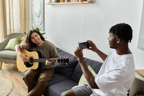 stock image A loving couple enjoys each other, making music and capturing memories at home.