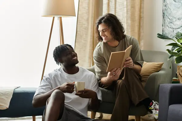 stock image A joyful couple sits together on a cozy couch, sharing coffee and a book in a serene living room.