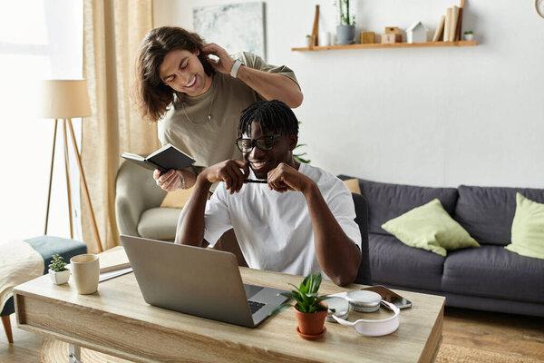 Радостный момент разворачивается, когда пара делится смехом и теплом, работая дома.