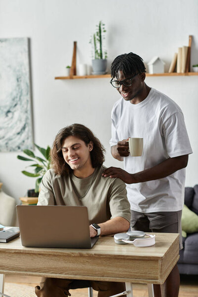 Радостная пара делится мгновениями дома, в то время как один партнер работает на ноутбуке.