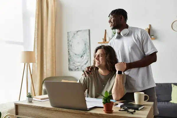 stock image Two partners share a loving moment while working together in their bright home office.