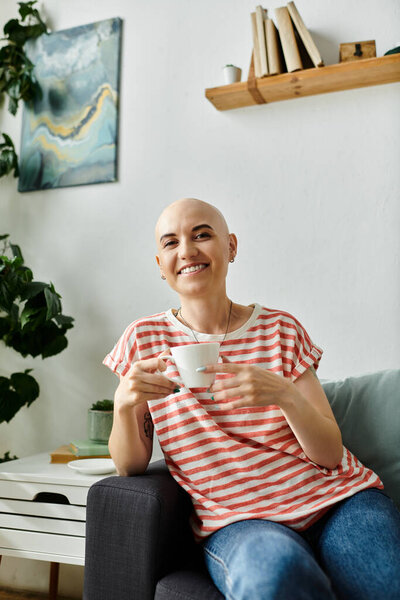 Молодая женщина с уверенной улыбкой пьет чай, сидя в ярком, привлекательном пространстве.