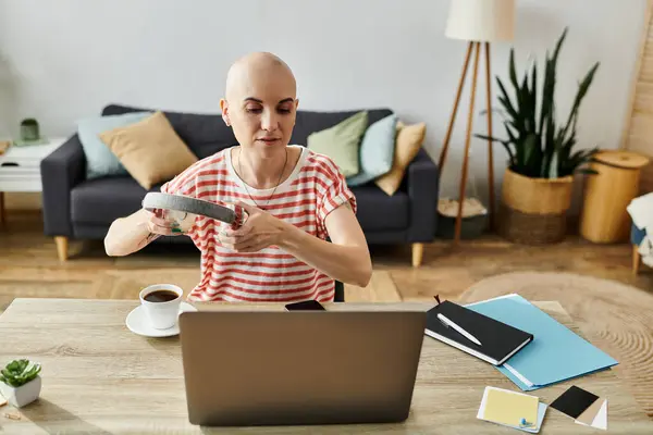 stock image The beautiful bald woman joyfully rearranges items at her desk, focused and engaged.