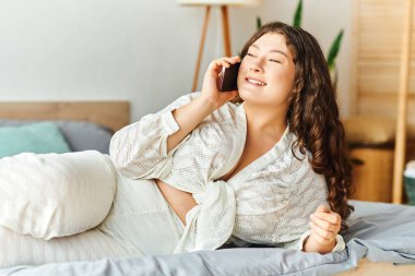 Neşeli, iri yarı bir kadın evinde dinleniyor. Kanepesinde derin bir telefon görüşmesi yapıyor..