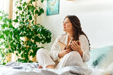 Evde dinlenen, güzel ve iri yarı bir kadın en sevdiği kitabı okumaktan zevk alıyor..