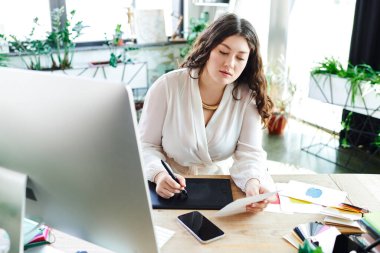 Genç ve iri yarı bir kadın yaratıcı bir şekilde meşgul, güzellik ve verimlilik sergiliyor..