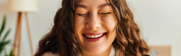 Молодая женщина излучает счастье, расслабляясь дома, наслаждаясь моментом радости и спокойствия.