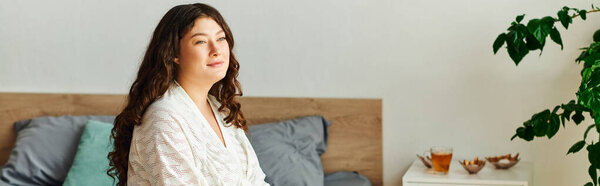 Женщина plus size наслаждается моментом спокойствия в своей спальне.