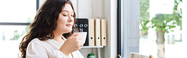 The beautiful plus size woman savors her drink, enveloped in morning tranquility at office.