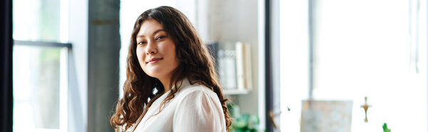 A young beautiful plus size woman stands confidently at office, radiating warmth and joy.