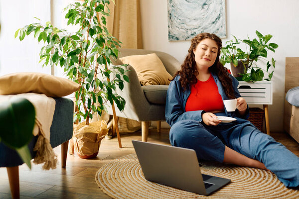 Отдых дома, красивая плюс размер женщина с вьющимися волосами лелеет ее спокойный момент за теплой чашкой чая.