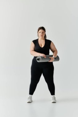 Kendine güvenen, iri yarı bir kadın yoga minderiyle dimdik ayakta duruyor. Parlak uzayda pratik yapmaya hazır..