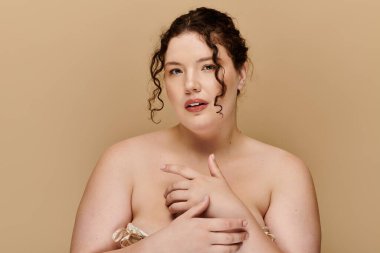 Kendine güvenen, iri yarı bir kadın zarifçe poz verir, zarafet ve güzellik saçar..