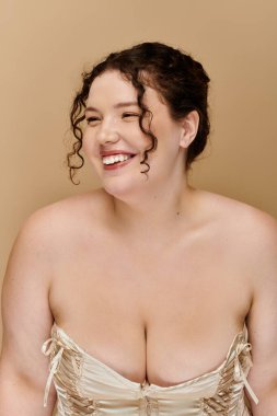 Güzel ve iri bir kadın büyük bir gülümsemeyle neşe saçar, özgüvenini ve zarafetini gösterir..