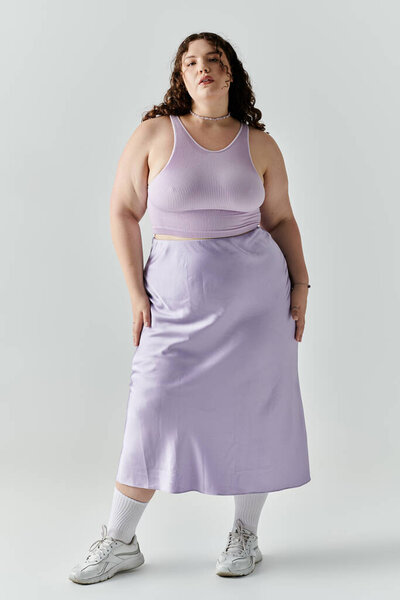 Изящный плюс размер женщина демонстрирует свой стиль в стильном ансамбле лаванды, источая уверенность.