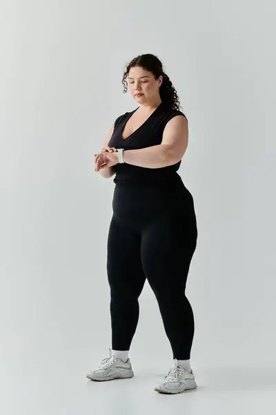 stock image A graceful plus size woman checks her watch, ready to embrace the day ahead.