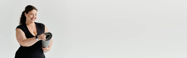 Красивая женщина плюс размер улыбается ярко, как она готовит коврик для йоги в спокойном пространстве.