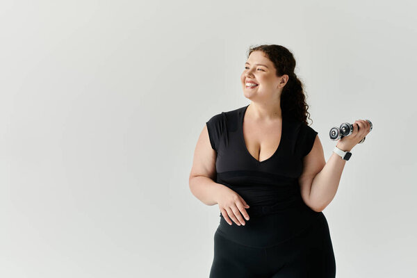 Уверенная и красивая женщина plus size улыбается, поднимая вес, излучая радость и силу.