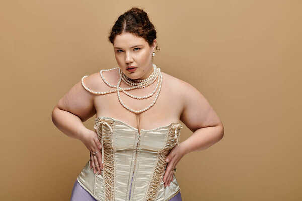 A beautiful plus size woman poses confidently, highlighting her elegant corset and pearls.