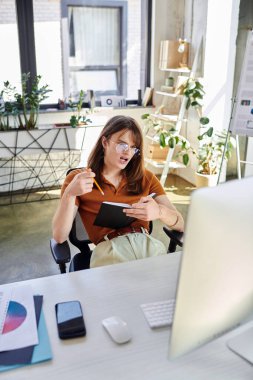 A young non binary person is brainstorming ideas while sitting at a stylish office desk. clipart