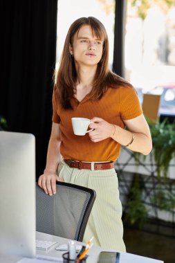 A young non binary individual stands at their desk, sipping coffee and reflecting thoughtfully. clipart