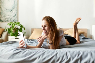 Genç bir kadın evde dinleniyor, günlük yaşamını sergilerken arkadaşlarıyla telefonda konuşuyor..