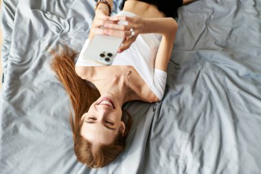 Bağlantı anında, genç bir kadın selfie çekerken gülümser, evde iyileşmesini kucaklar..