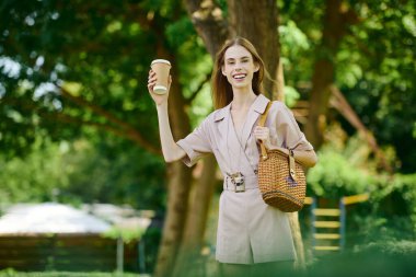 A young woman with anorexia revels in nature, holding a coffee cup while joyfully soaking up the sun warmth. clipart