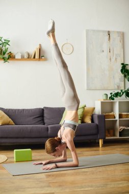 Huzurlu bir oturma odasında iştahsızlığı olan genç bir kadın günlük yolculuğunu somutlaştırmak için yoga pozu verir..