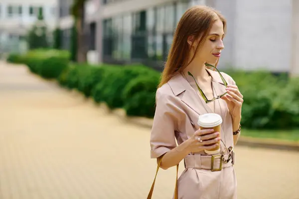 stock image A young woman with anorexia delighting in her surroundings, sipping coffee with a joyful expression under the sun.