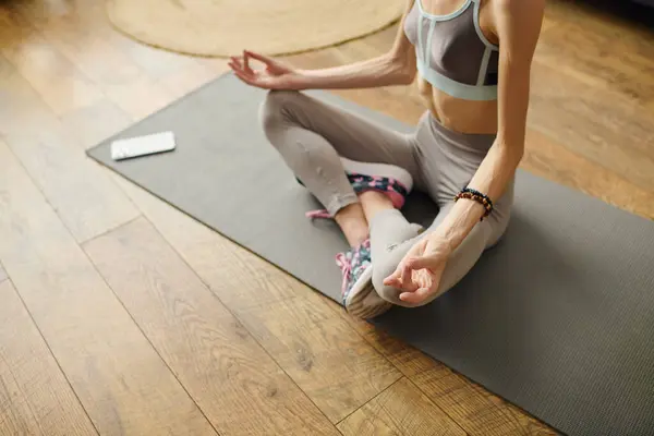 stock image A young woman is engaged in yoga at home, focusing on her mental well-being and physical health daily.