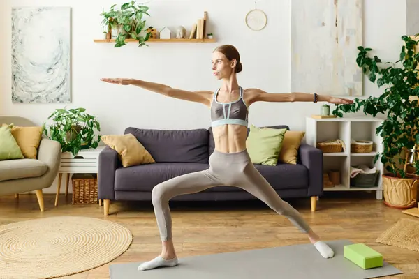 stock image In a serene living room, a young woman with anorexia diligently engages in her daily workout routine.