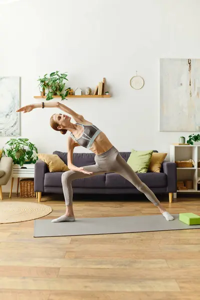 stock image In a cozy living room, a young woman with anorexia embraces her wellness journey through yoga, discovering strength and balance.